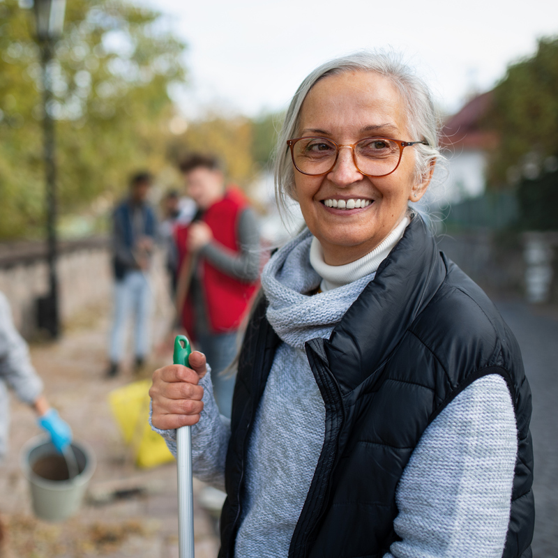 woman with group of people doing clean up work outsite