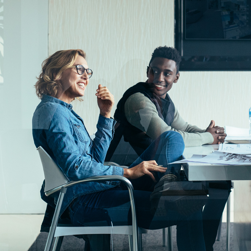 man and woman smiling in meeting