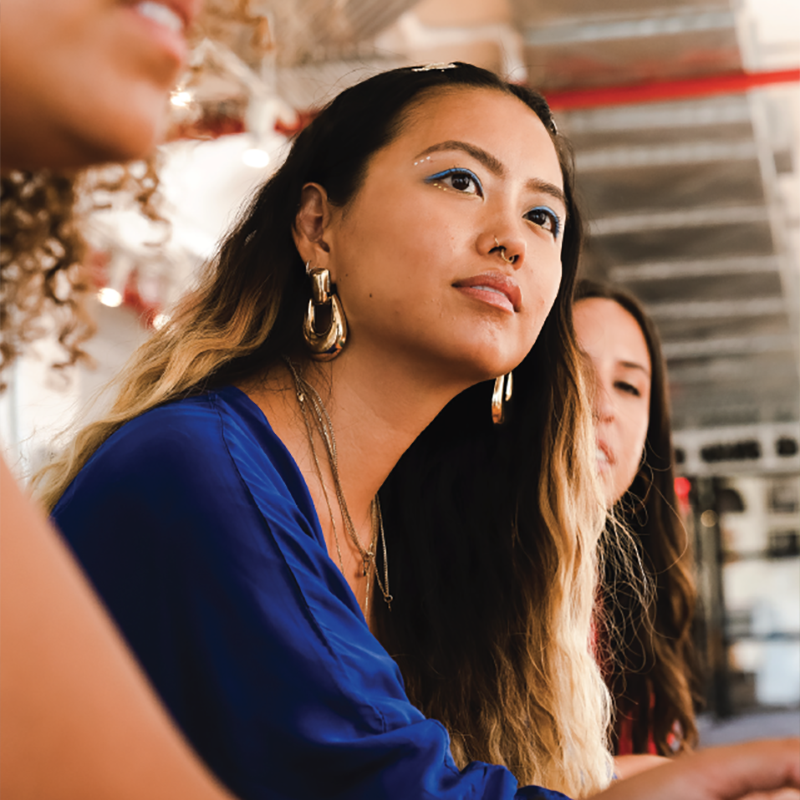 woman in a group setting listening to speaker